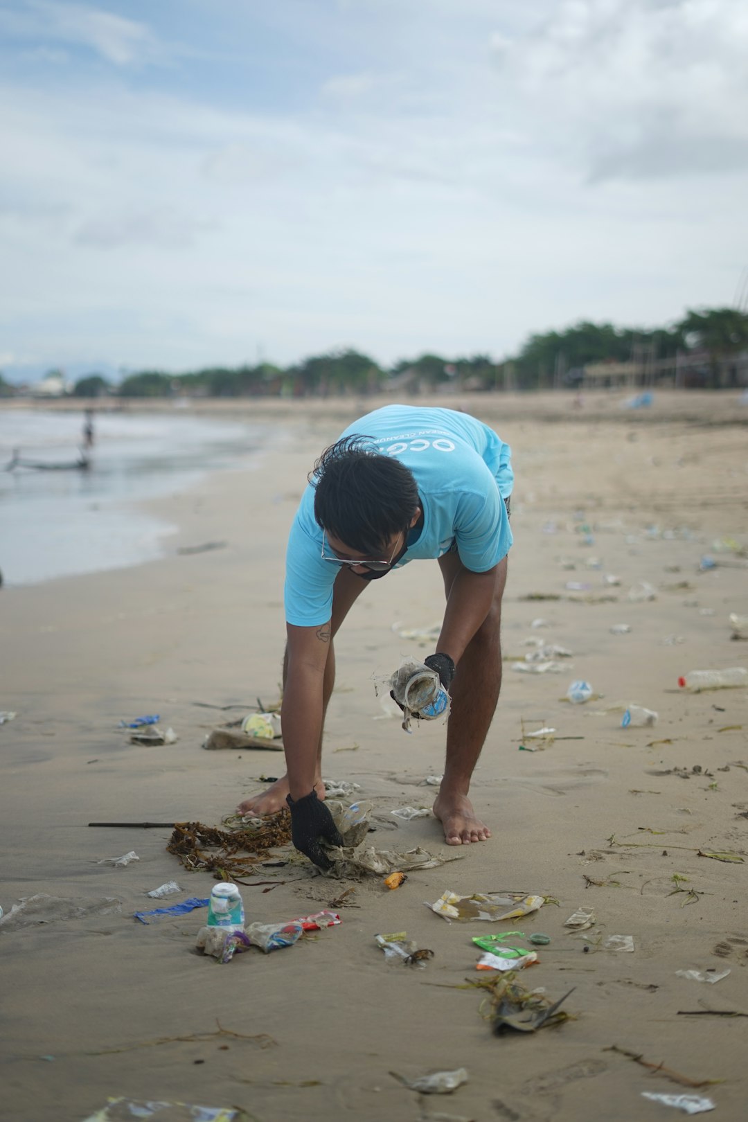 digital picking up plastic on the beach